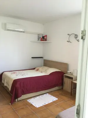a bedroom with a bed and a tiled floor at Maison au calme avec terrain et vue sur la mer in Poggio-Mezzana