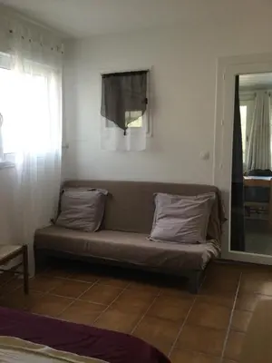 a couch sitting in a room with a window at Maison au calme avec terrain et vue sur la mer in Poggio-Mezzana