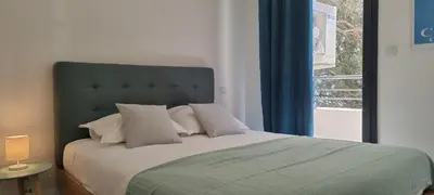 a bedroom with a large bed with a window at Appartement T3 proche du Port in Porto-Vecchio