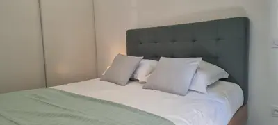 a bedroom with a large bed with white pillows at Appartement T3 proche du Port in Porto-Vecchio