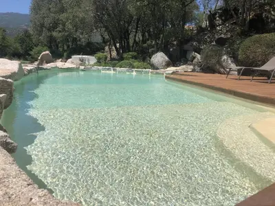 a swimming pool with blue water in a yard at Domaine Pardini in Porto-Vecchio