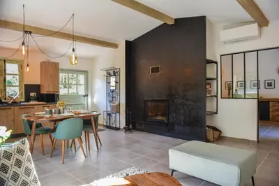 a living room with a fireplace and a table and chairs at Domaine Pardini in Porto-Vecchio