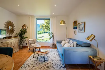 a living room with a blue couch and a table at Domaine Pardini in Porto-Vecchio
