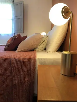 a bed with pillows and a lamp on a table at Domaine Pardini in Porto-Vecchio
