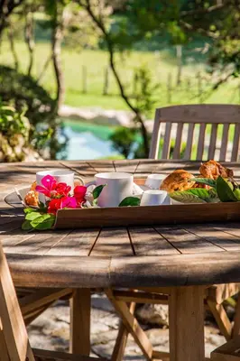 a wooden table with a tray of food and flowers at Domaine Pardini in Porto-Vecchio