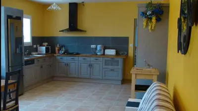 a kitchen with blue cabinets and a yellow wall at VILLA 4pers, STUNNING SEA VIEW, BEACH ON FOOT 4* in Olmeto