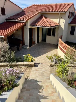a house with a brick walkway in front of it at Charmante petite maison magnifique vue mer in Propriano
