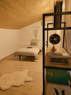 a bedroom with a bed and a desk with a lamp at Charmante petite maison magnifique vue mer in Propriano