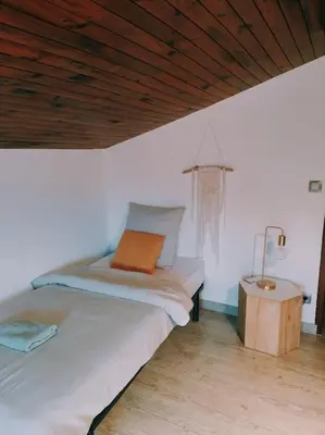 a bedroom with a bed with an orange pillow and a table at Charmante petite maison magnifique vue mer in Propriano