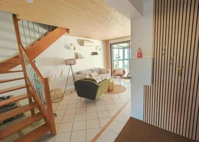 a living room with a staircase and a couch at Charmante petite maison magnifique vue mer in Propriano