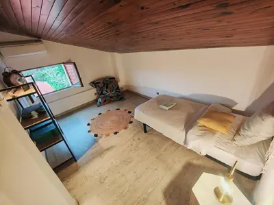 a small room with a bed and a wooden ceiling at Charmante petite maison magnifique vue mer in Propriano