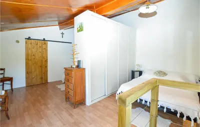 a bedroom with a bed and a wooden dresser at Cozy Home In Coti-Chiavari in Coti-Chiavari