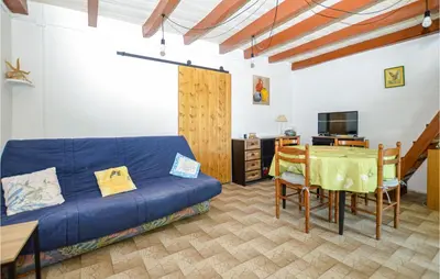 a living room with a blue couch and a table at Cozy Home In Coti-Chiavari in Coti-Chiavari