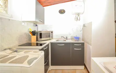 a small kitchen with a sink and a microwave at Cozy Home In Coti-Chiavari in Coti-Chiavari