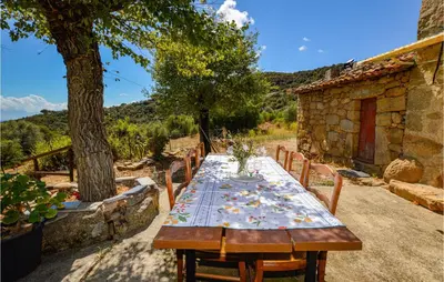 a wooden table with a floral table cloth on it at Cozy Home In Coti-Chiavari in Coti-Chiavari