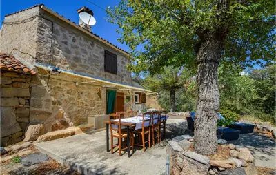 a table and chairs in front of a house with a tree at Cozy Home In Coti-Chiavari in Coti-Chiavari