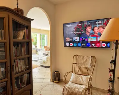 a living room with a flat screen tv on the wall at Villa Casa Bianca Sagone Piscine privée et Vue mer Familiale in Sagone