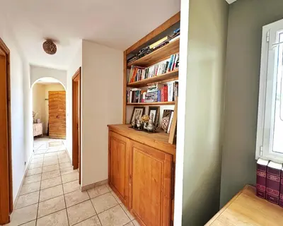a hallway with a book shelf with books at Villa Casa Bianca Sagone Piscine privée et Vue mer Familiale in Sagone