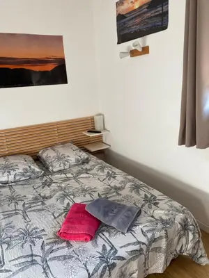 a bedroom with a bed with a red pillow on it at Chambre chez l habitant 2 nuit maximum !! Une 2 eme chambre possible in Porticcio