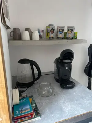 a kitchen counter with a coffee maker and books on a shelf at Chambre chez l habitant 2 nuit maximum !! Une 2 eme chambre possible in Porticcio