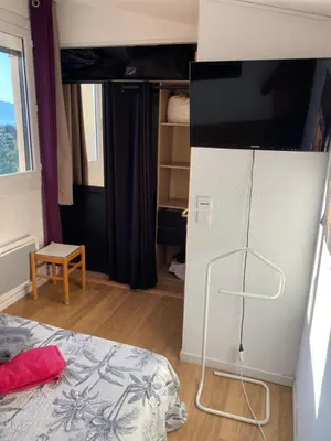 a bedroom with a bed and a television on a stand at Chambre chez l habitant 2 nuit maximum !! Une 2 eme chambre possible in Porticcio