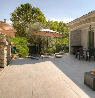 a patio with an umbrella and a table and chairs at Casa santoni 20 in Grosseto-Prugna