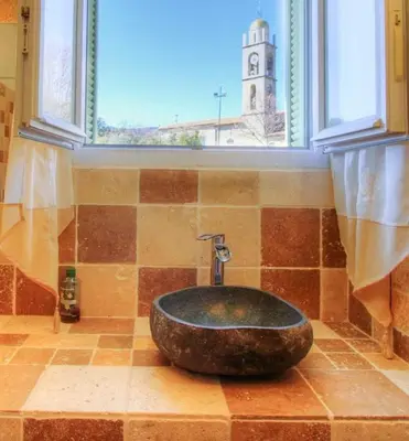 a bathroom with a stone sink in front of a window at Casa santoni 20 in Grosseto-Prugna