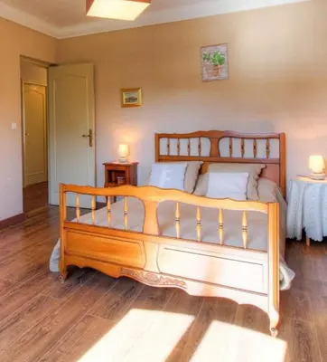 a large wooden bed in a room with wooden floors at Casa santoni 20 in Grosseto-Prugna