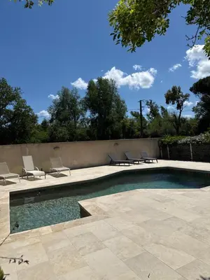 a swimming pool with lounge chairs next to a wall at casa SamaSama in Porto-Vecchio