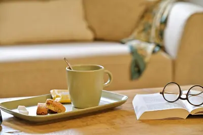 a table with a coffee cup and a plate of food and a book at COCO in Venaco