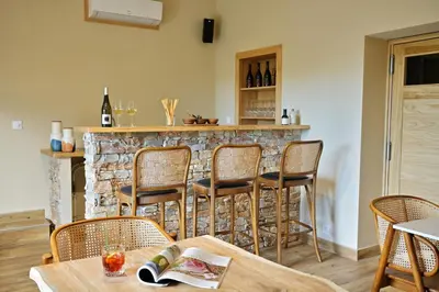 a room with a bar with chairs and a table at COCO in Venaco
