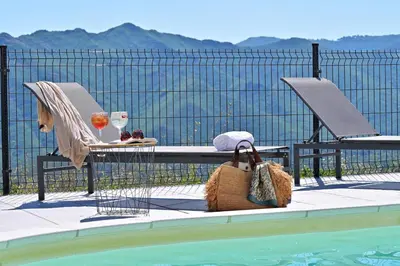 a table and two chairs next to a swimming pool at COCO in Venaco