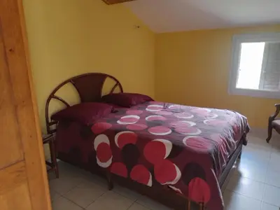 a bedroom with a bed with a red and white blanket at Maison de caractère au coeur de la corse rurale in Calacuccia
