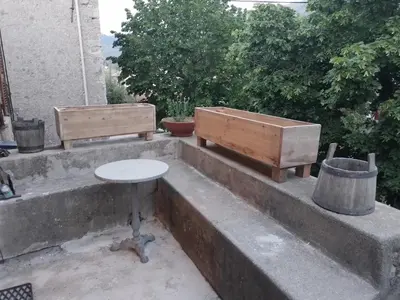 two benches and a table on a concrete ledge at Maison de caractère au coeur de la corse rurale in Calacuccia
