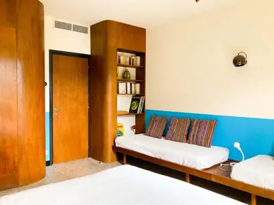 a bedroom with two beds and a book shelf at Villa esprit moderniste avec piscine in Bonifacio