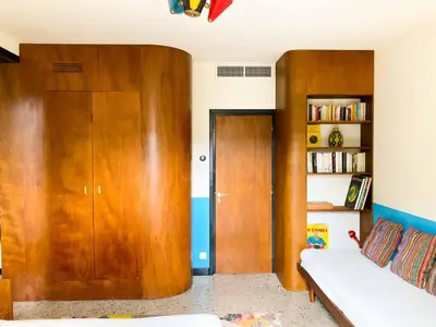 a living room with a couch and a wooden door at Villa esprit moderniste avec piscine in Bonifacio
