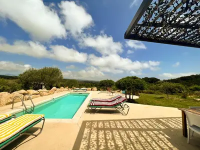 a swimming pool with two lounge chairs next to it at Villa esprit moderniste avec piscine in Bonifacio