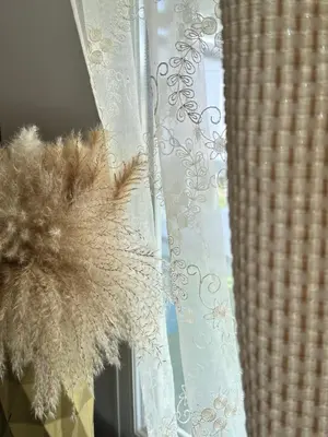 a window with a white curtain with a brown furry object at les bungalows de Lisa Maria in SERRA DI FIUMORBO