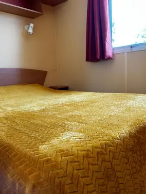 a large bed in a room with a window at les bungalows de Lisa Maria in SERRA DI FIUMORBO