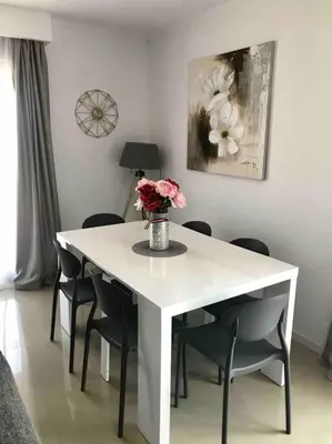 a white table with chairs and a vase of flowers on it at maison cosy climatisée avec piscine et jardin in Calenzana