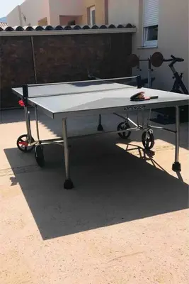 a ping pong table sitting in front of a building at maison cosy climatisée avec piscine et jardin in Calenzana