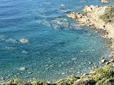 a large body of water with a rocky shore at Domaine de la Coletta Bergerie in Coti-Chiavari