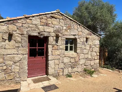 a small stone building with a red door at Domaine de la Coletta Bergerie in Coti-Chiavari