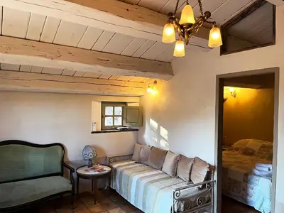 a bedroom with a bed and a chair and a table at Domaine de la Coletta Bergerie in Coti-Chiavari
