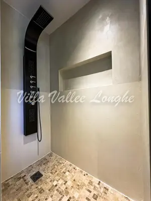 a bathroom with a shower with a wall with a shelf at Villa Talasani in Talasani