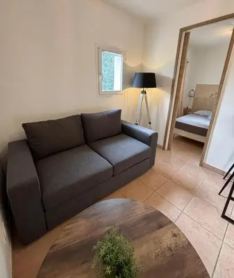 a living room with a couch and a mirror at Charmante maisonnette situé au calme proche d'Ajaccio. in Afa
