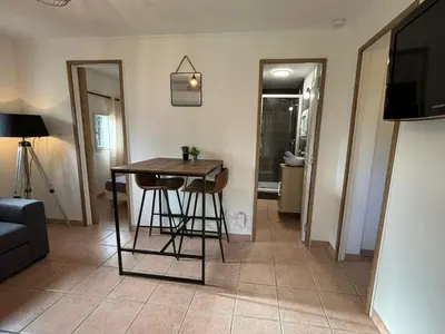 a living room with a table and a couch at Charmante maisonnette situé au calme proche d'Ajaccio. in Afa