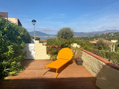 a yellow chair sitting on a wooden deck at Terra Bella - mini Villa vue mer in Grosseto-Prugna