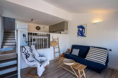 a living room with a blue couch and a chair at Terra Bella - mini Villa vue mer in Grosseto-Prugna