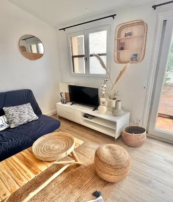 a living room with a blue couch and a tv at Terra Bella - mini Villa vue mer in Grosseto-Prugna